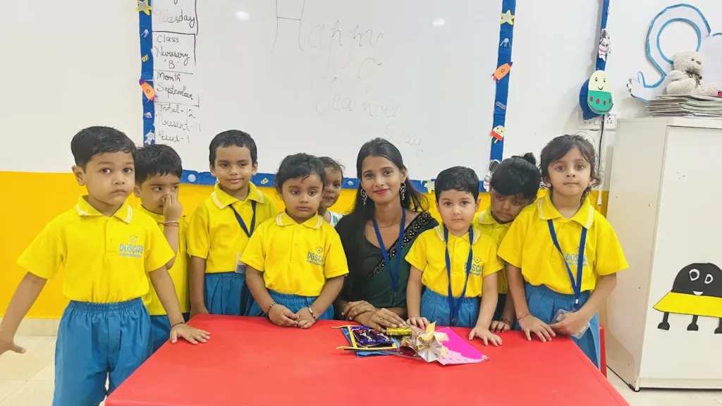 Group of children celebrating Teacher Day with their teacher, holding gifts and smiling